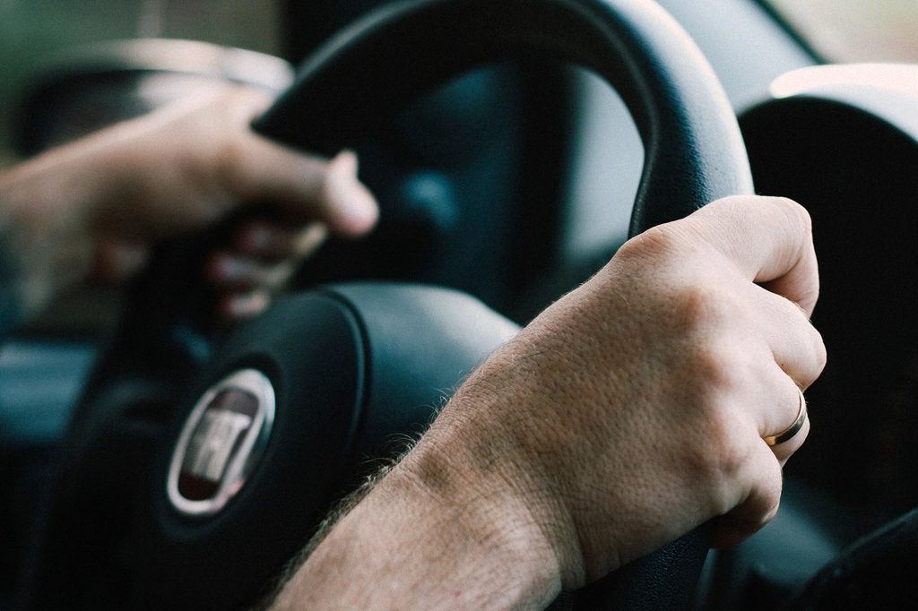 Manos de un conductor sobre el volante, con el claxon en el centro